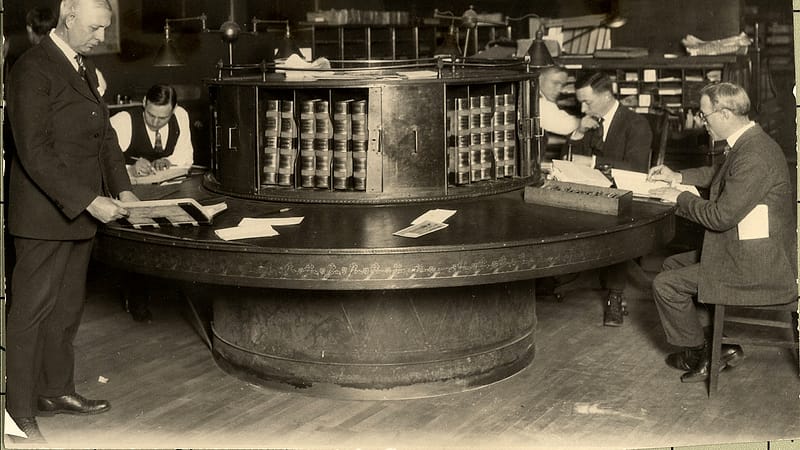 A clerk's counter in a courthouse with numbered file drawers and a service window behind it.