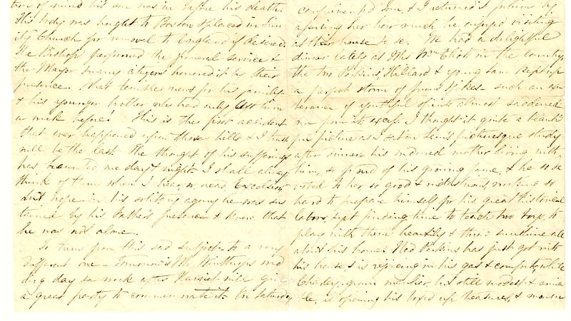 A ledger of handwritten entries lies open in an archive room lined with numbered document boxes.