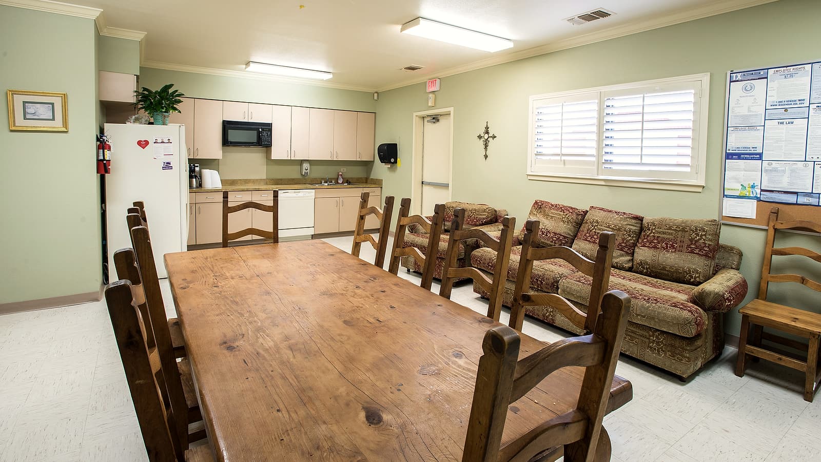 A small rural clinic building with a gravel parking lot and a single ambulance parked outside.